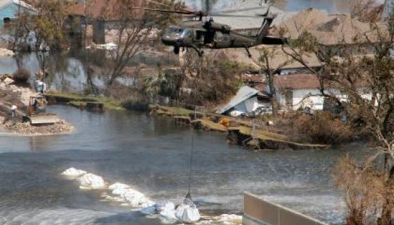 A Texas Army National Guard Blackhawk deposits a 6,000 pound-plus bag of sand and gravel to help close the breach in the 17th Street Canal in New Orleans following Hurricane Katrina in 2005. Photo Courtesy WIkimedia Commons