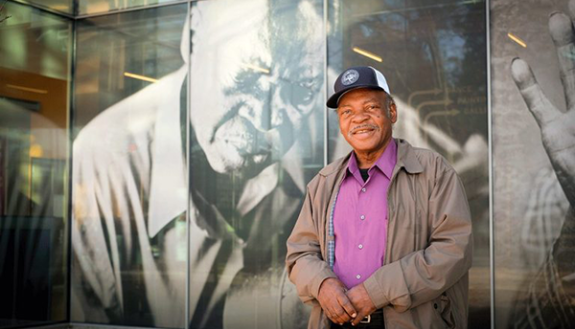 Performer Willie Farmer, in front of a tin type portrait by Timothy Duffy