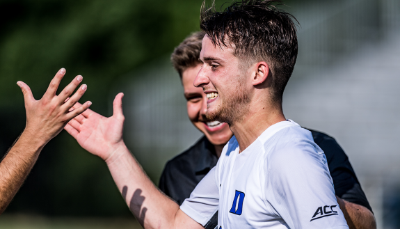 Daniele Proch with teammates on the soccer field