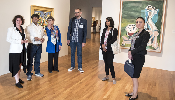 Nasher Museum Director Sarah Schroth leads five visiting cultural preservation experts into the entrance of Wilson Pavilion, pausing in front of paintings by Fernand Léger, Paysage a l'oiseau (left) and Pablo Picasso, Joueur de Flûte et Mangeur de Pastèqu