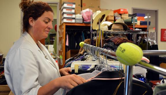 Sarah Walker, a manager at the Nearly New Shoppe, sorts through recently donated shirts and coats. The store, which supports medical and nursing scholarships, is seeking additional donations in the next two weeks.