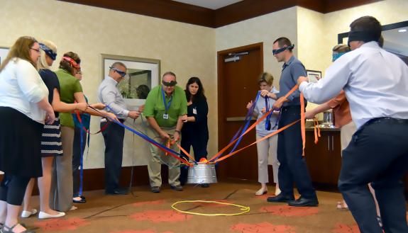 Class members in a "Guide to Managing at Duke" class participate in a blindfold activity to demonstrate the value of teamwork and communication. Photo by Bryan Roth.