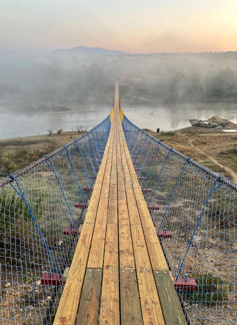Though built with rudimentary materials, this bridge bears the imprint of a hundred minds and hands. Its fencing is painted in the national colors of Eswatini: red, yellow, and blue. Photo by Kyle Abrahm.